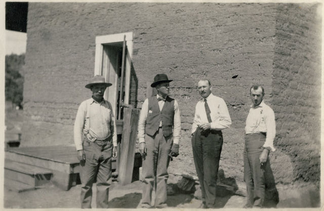 Cuatro empleados de la compañía fuera de adobe edificio, Cananea, México